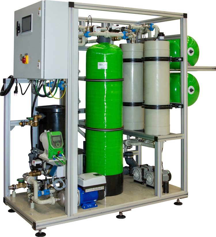 Industrielles Wasserfiltrationssystem mit grünen und grauen Behältern, Rohrleitungen und Steuerungseinheit auf Metallrahmen, geeignet für Gebäudetechnik.