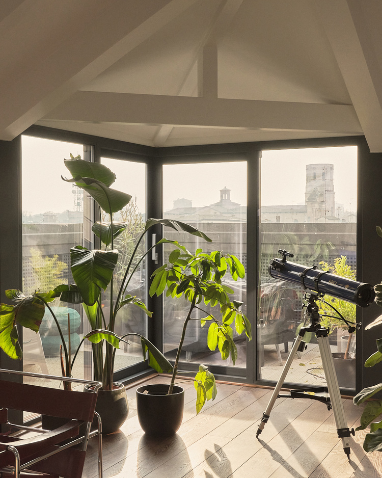Lichtdurchflutete Gebäudeecke mit großen Energiesparfenstern, begrüntem Innenraum und Ausblick, Fokus auf Tageslichtnutzung und Energieeffizienz.
