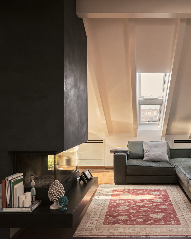 Moderner Wohnraum im Dachgeschoss mit Tageslicht über Dachflächenfenster, energieeffizientem Kamin und moderner Heiztechnik, Fokus Gebäudeenergie.