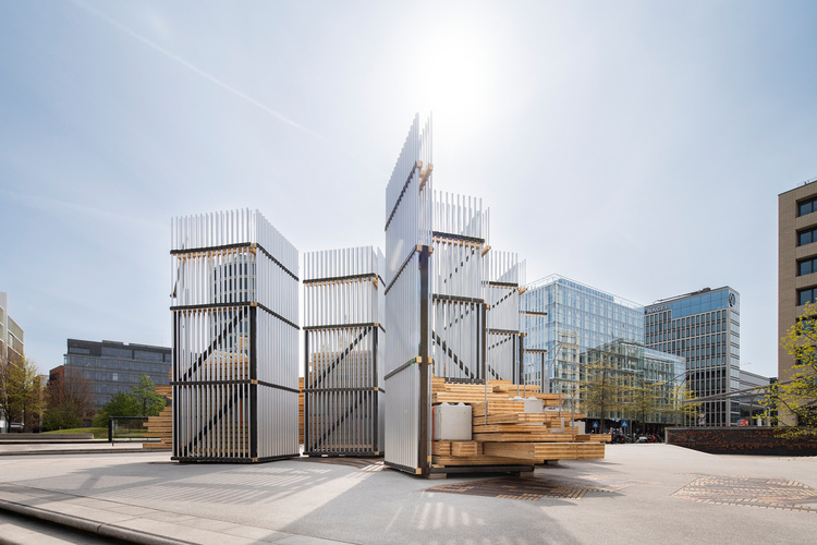 Detailaufnahme einer modernen Fassadenlösung mit Holz- und Metallpaneelen im urbanen Umfeld, geeignet für energieeffiziente Gebäudetechnik.