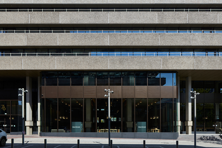 Außenansicht eines modernen, mehrstöckigen Bürogebäudes mit großer Glasfassade - typisches Beispiel für Gebäudetechnik im Nichtwohnungsbau.