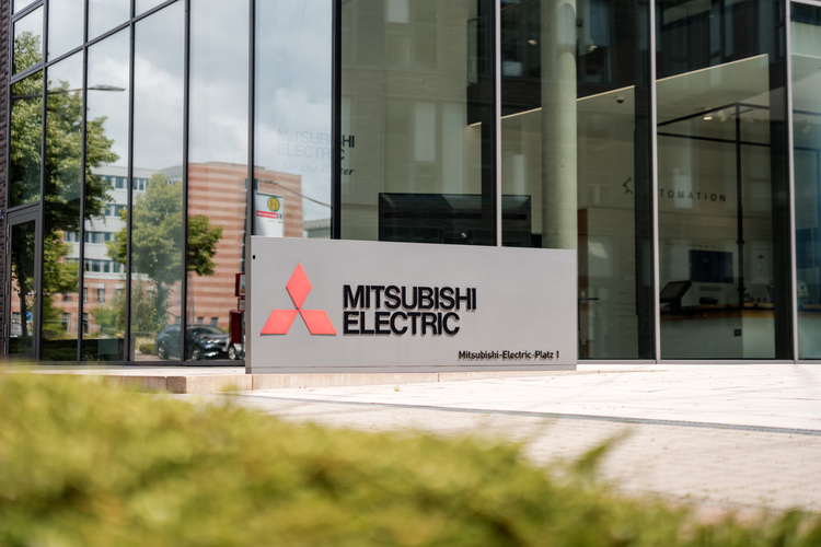 Eingangsbereich eines Mitsubishi Electric Bürogebäudes mit großem Firmenschild, relevant für Gebäudetechnik und HLK-Lösungen im B2B-Bereich.