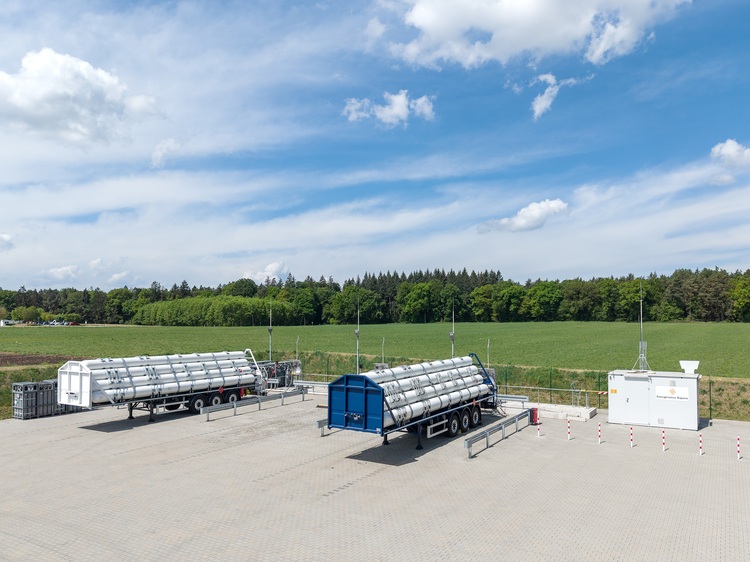 Zwei große Tankauflieger und ein Technikcontainer auf asphaltiertem Gelände, ideal für die temporäre Energieversorgung in der Gebäudetechnik.