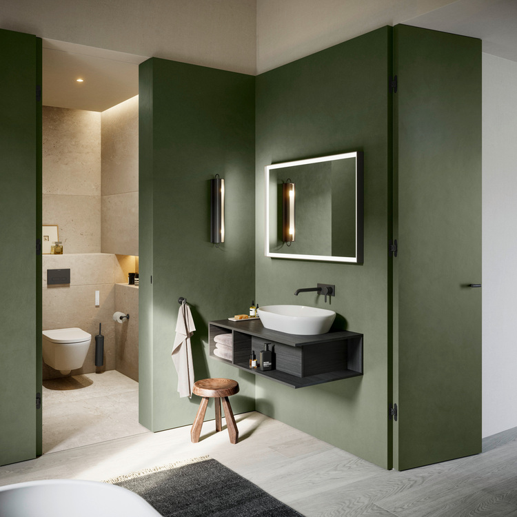 Barrierefreies Bad mit grünen Wänden, wandhängendem Waschtisch, rundem Spiegel und separater Toilettennische – moderne Sanitär-, Heizungs- und Klimatechnikplanung.