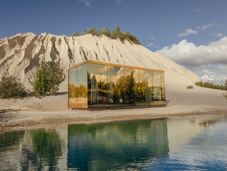 Spiegelverglaste Modulbauweise: Die Kabine spiegelt Bäume und Himmel am Seeufer wider. Der Fokus liegt auf einer energieeffizienten Gebäudehülle in moderner Architektur.