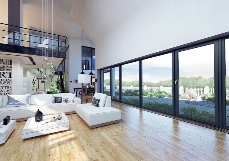Wohnraum mit großzügigen Fensterflächen, natürlicher Beleuchtung, nachhaltigen Materialien und Blick auf einen effizient gestalteten Garten zur Veranschaulichung der Gebäudetechnik.