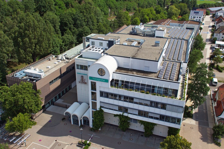 Luftaufnahme eines modernen Krankenhausgebäudes mit einer Photovoltaikanlage auf dem Dach, umgeben von Grünflächen – mit Schwerpunkt auf Energieeffizienz und Gebäudetechnik.