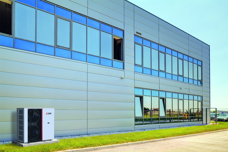 Moderne Gewerbeimmobilie mit großen Fensterflächen und einer außen montierten Mitsubishi-Klimaanlage – ein Beispiel für energieeffiziente Gebäudetechnik.