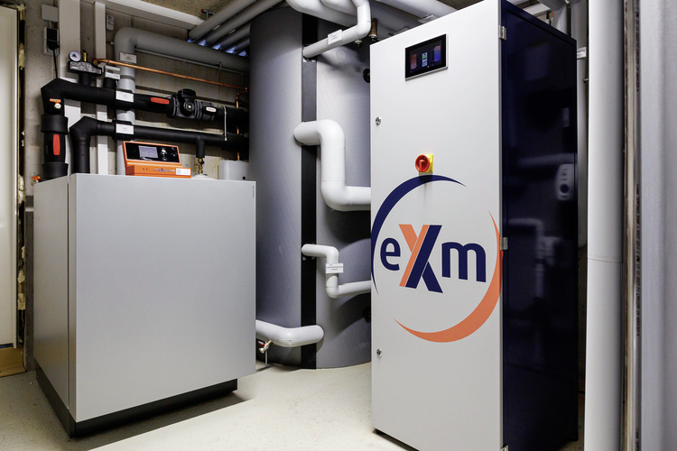 Moderne Gebäudetechnik: Industrielle Steuerungsanlagen mit „exm“-Bedienfeldern und Rohrleitungen in einem hygienischen Technikraum.