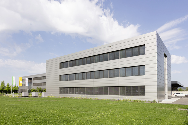 Modernes Bürogebäude mit Metallfassade und großen Fenstern, das als Beispiel für eine energieeffiziente Gebäudehülle in der Gebäudetechnikbranche dient.