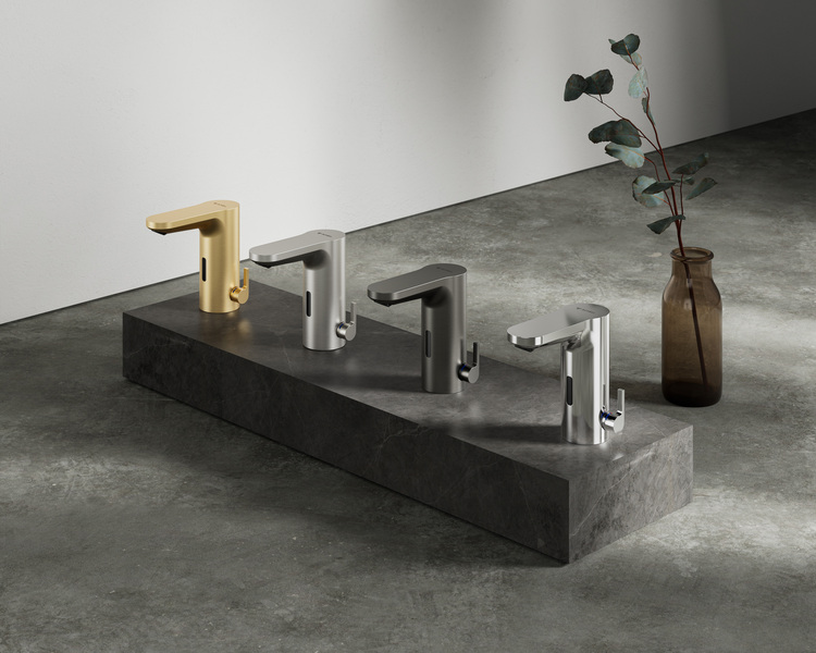 Vier Design-Armaturen in Gold, Silber und Schwarz auf einem Steinpodest, daneben eine braune Vase mit einer Grünpflanze – Produktpräsentation für eine Badezimmerausstattung.