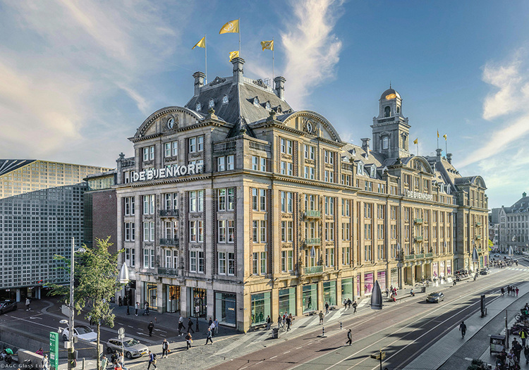 Historisches Gebäude mit Steinfassade und Schaufensterfront an einer belebten Straßenecke als Beispiel für energetische Sanierung und Gebäudehülle.