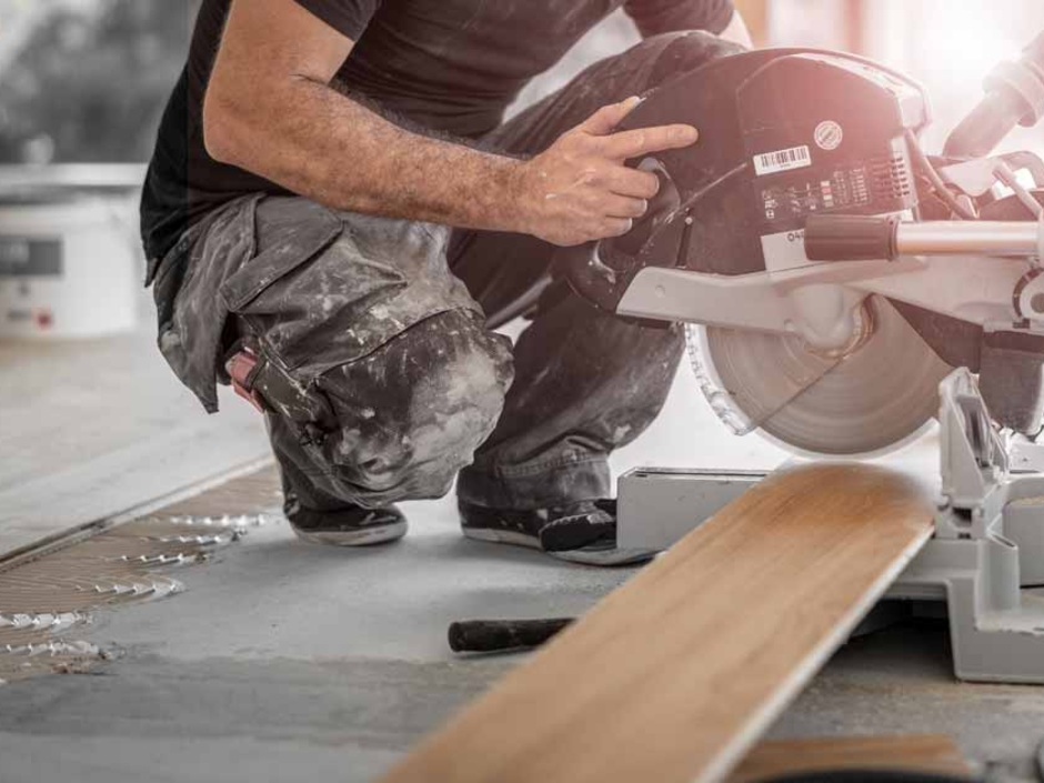 Ein Handwerker schneidet eine Holzdiele.