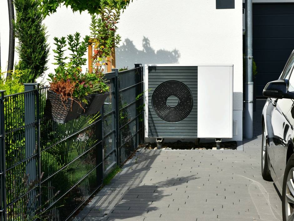 Wärmepumpe, Klimaanlage, Luftwärmepumpe für Heizung und Warmwasser vor einem neu gebauten Wohnhaus
