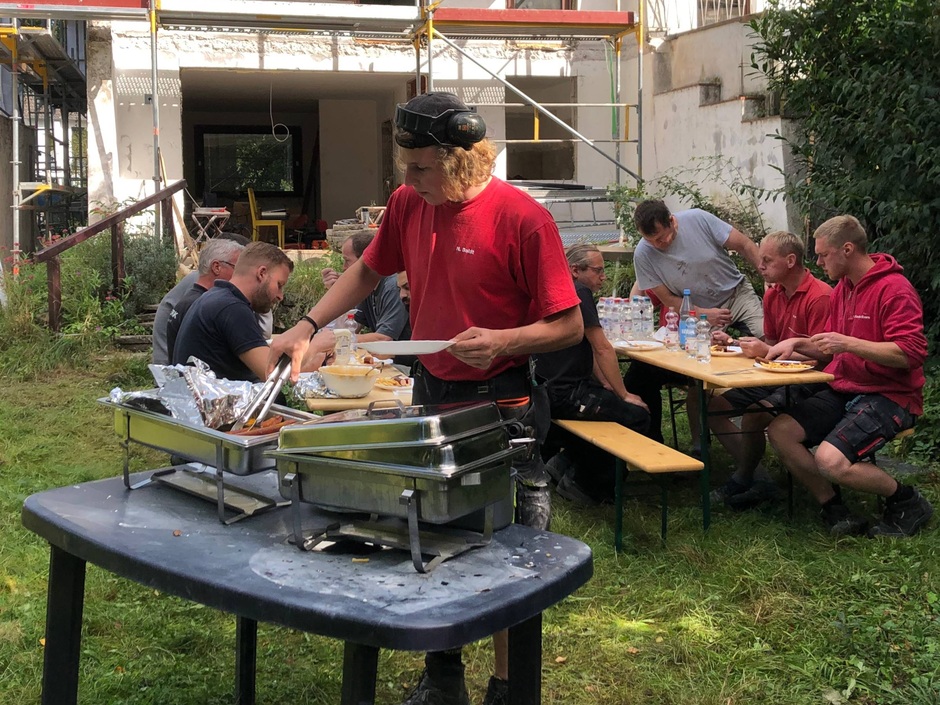 Besser durch richtige Pausen: Beim gewerkübergreifenden Mittagessen kommen die Profis der verschiedenen Disziplinen zusammen, lernen sich kennen und vertrauen und können so gut aufeinander abgestimmt zusammenarbeiten.