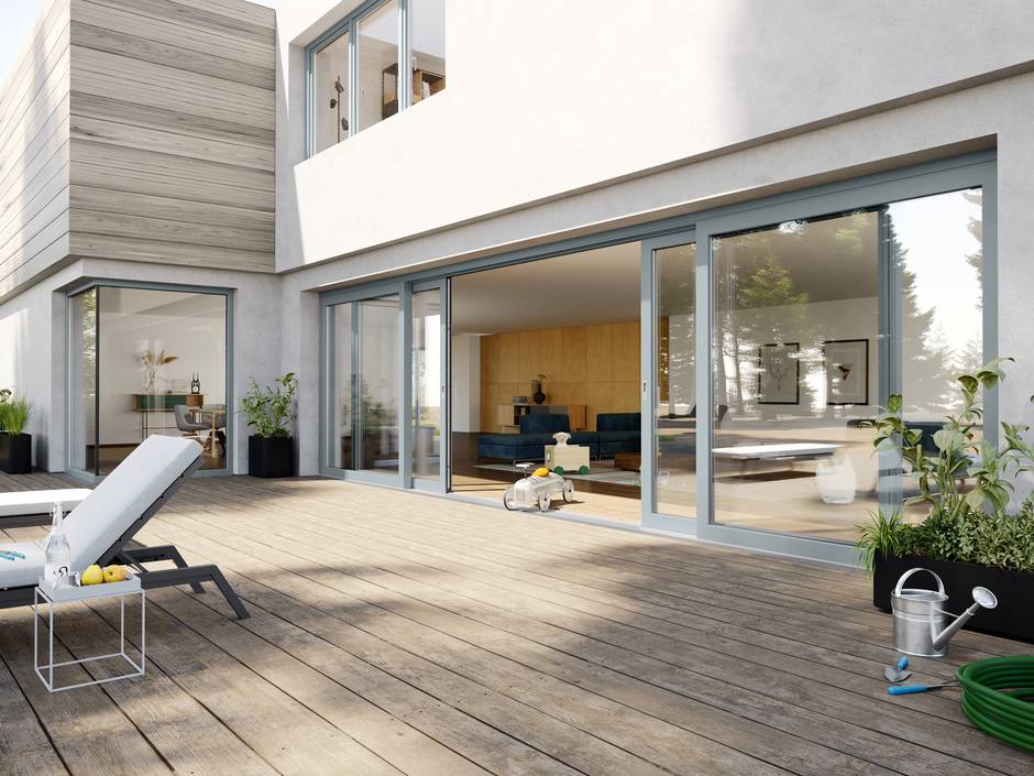 Der Garten wird zum erweiterten Wohnzimmer mit großen Hebe- und Schiebetüren. Die Profile sind in silbergrau gehalten.