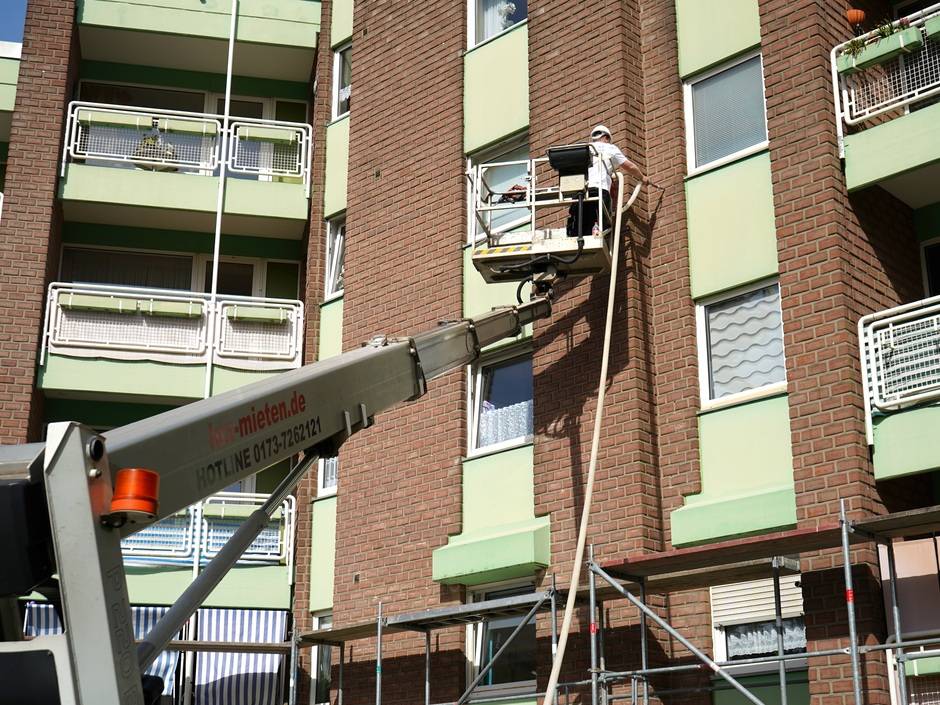Arbeiter auf einem Hubsteiger an einer Fassade