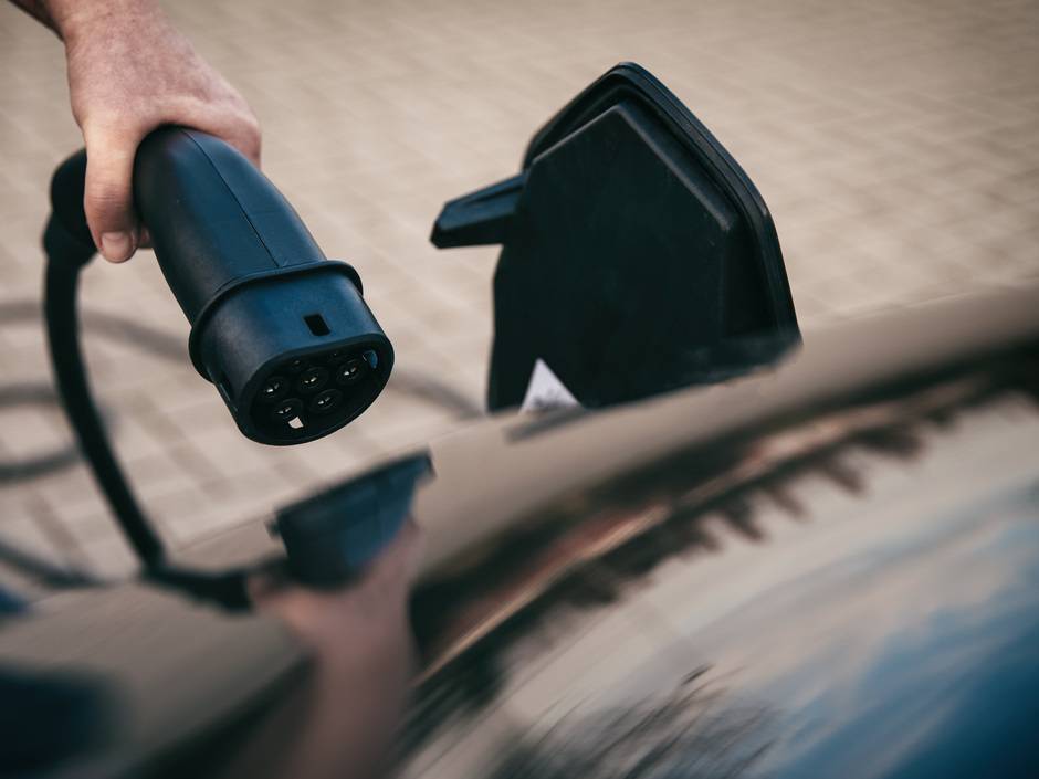 Hand hält Ladestecker