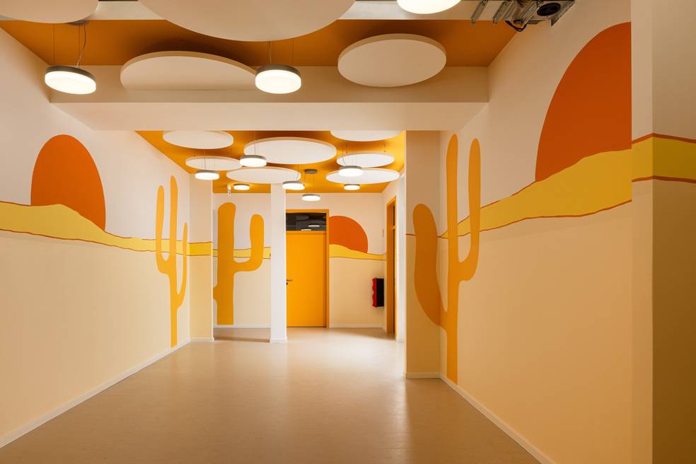 ALT-Text: Moderne Flurgestaltung in einem Gebäudetechnikunternehmen mit hellen LED-Deckenleuchten, Wänden mit energieeffizientem Wärmedämmputz und nachhaltigen Bodenbelägen in Erdtönen.