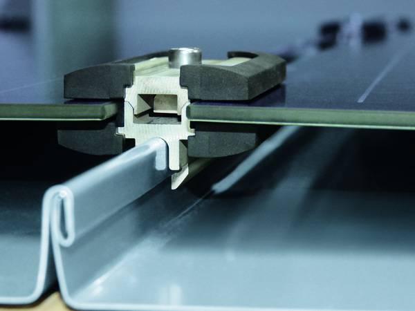 Mit nur einer Schraube wird die patentierte Falz- und Modulklemme mitsamt der Module fixiert. Mit nur einer Schraube wird die patentierte Falz- und Modulklemme mitsamt der Module fixiert.