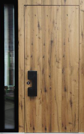 Die Holzhaustür HT 3-90 Modern von Kneer-Südfenster als Sondermodell „Scheune“ in gebürstetem Eiche-Altholz mit Griff „Spanischer Schmied“ und Automatikschloss.