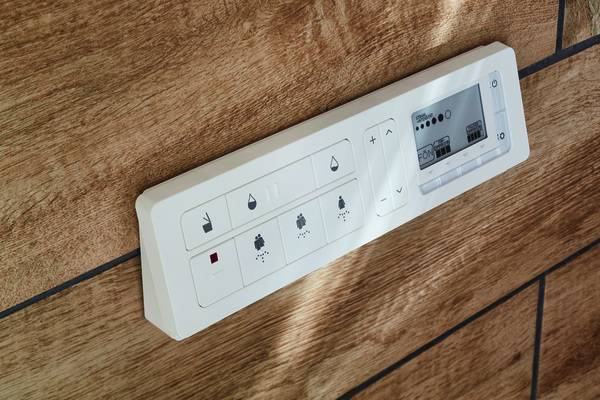 Zusätzlich zur Bedienungseinheit an der Wand gibt es auch eine Fernbedienung.