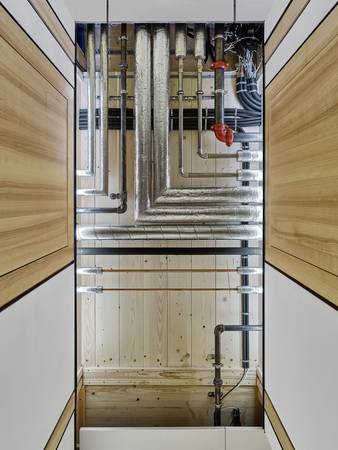 Teile der Wand- und Deckenverkleidung sind bewusst ausgespart, um die Struktur und die Materialität der Einheit besser sichtbar zu machen.