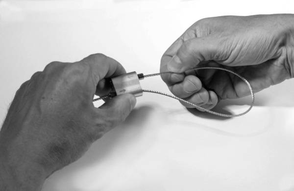 Bei der Montage ist das Seil einfach durch die Seilklemmen in Pfeilrichtung zu schieben. Das Eindrücken der Klemme löst die Verbindung wieder, so dass sich die Abhängung ohne Werkzeug korrigieren lässt. 