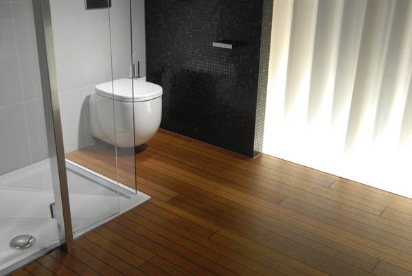 Da Holz ein eher warmes Material ist, bietet es sich auch als Fußbodenbelag im Bad an. Besonders dann, wenn das Bad direkt an ein Schlafzimmer mit Holzfußboden angrenzt.
