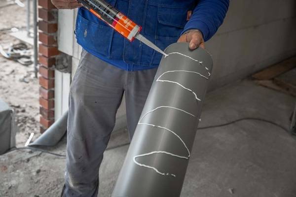 Einsetzen des Montagerohrs: Im nächsten Schritt wird der Montagekleber auf die Außenseite des Rohrs aufgetragen. Anschließend wird es in die Öffnung im Einbau-Montagestein geschoben. 