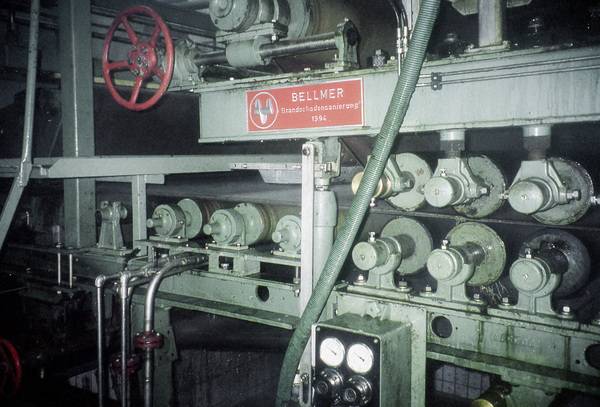 Auf Langsieben wird dem Faserkuchen etwa 50% des Wassers entzogen und Presswalzen bringen den Holzbrei in Plattenform.