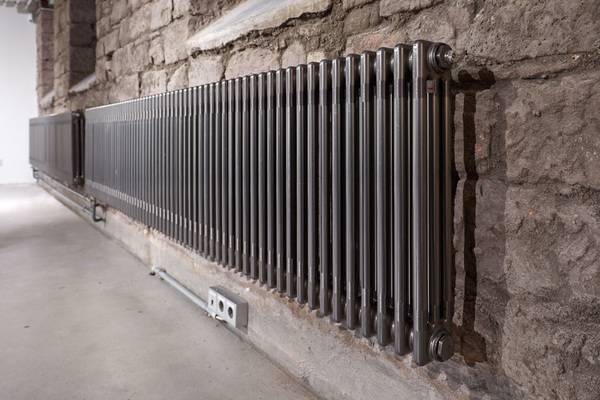 Befestigt an dunkelgraue, rustikale Steinwände erfüllt Zehnder Charleston die komplexen Bedingungen des Einbaus in ein denkmalgeschütztes Gebäude und unterstreicht zugleich den Industriecharme, der die historische Bausubstanz ausmacht.