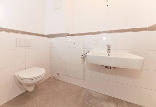 Im neuen Bad können sich die Bewohner über eine schöne, moderne Farbgestaltung und Sanitärprodukte freuen. WC und Waschtisch stammen aus der Badserie Geberit Renova.