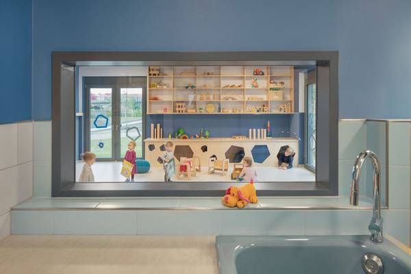 Auf den Wickelkommoden sind bermudablaue BetteDelta Duschwannen mit Hahnloch zu Waschtischen mit Armatur umfunktioniert. 