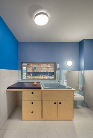 Durch die Innenfenster in der Wand können die Kinder weiterhin mit der Gruppe verbunden sein.