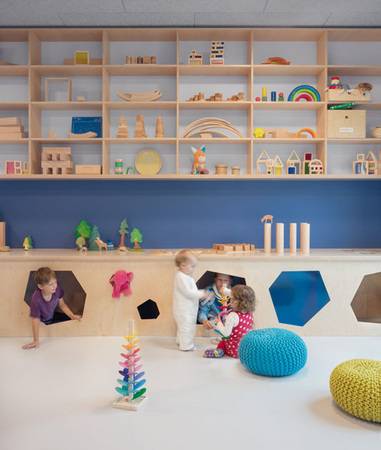 Alle Räume sind mit maßgeschneiderten, hellen Holzmöbeln ausgestattet. Sie bilden einen warmen Kontrast zur blauen Wandfarbe.