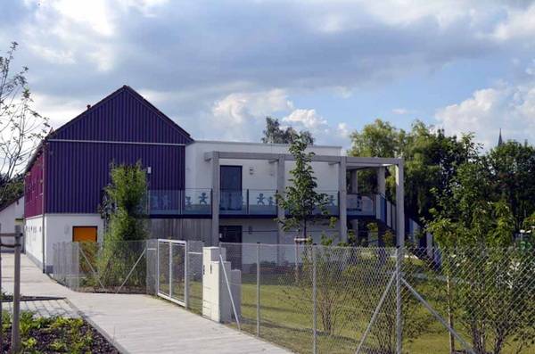 Die Dächer sind je nach Gebäudeseite unterschiedlich gestaltet: Zur Straßenseite hin wurde ein klassisches Satteldach mit Ziegeldeckung aufgesetzt, während die Gartenseite ein flaches Gründach mit massiver Attika und vorgelagerter Hochterrasse trägt.