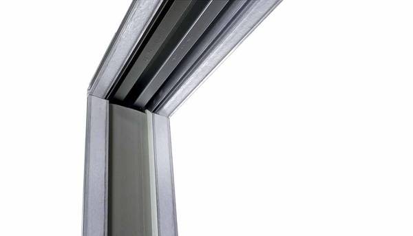 Eine abziehbare graue Schutzfolie schützt die Zarge der Schiebetür im Durchgangsbereich gegen Staub und Dreck auf der Baustelle. Im Bild wurde bereits die Schutzfolie von der Laufschiene entfernt.