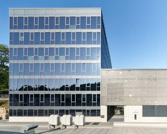 Die neue Produktionshalle dockt unmittelbar an das gläserne Bürogebäude an. Umhüllt ist sie mit dem vorgespannten Textilgewebe FACID 65. 