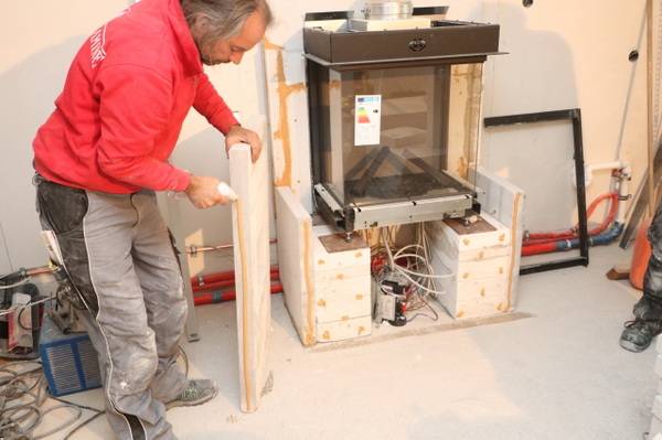 Jetzt stellt der Ofensetzer mit den Calciumsilikat-Dämmplatten die Ofenhülle her. Im Stoß- und Sockelbereich werden die Platten dabei mit einem speziellen, hochhitzebeständigen Dämmplattenkleber verklebt...