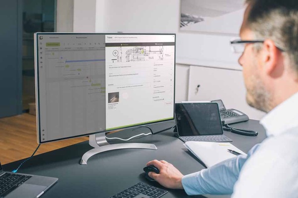 Bauleiter bei der Nutzung von Capmo am Computer. Bei der Bearbeitung des Bauzeitenplans, klickt er sich in offene Aufgaben hinein und kann diese dort bearbeiten.