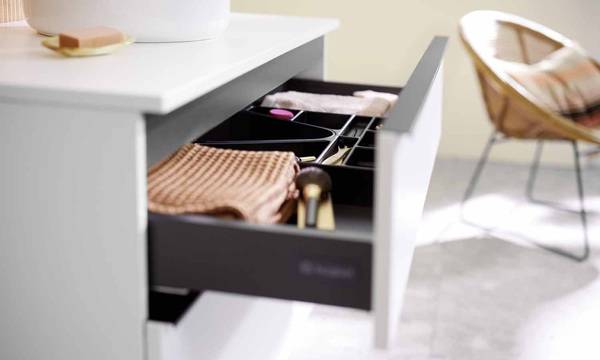 Die neue, über die gesamte Frontbreite der Auszüge gehende Griffleiste unterstreicht den horizontalen Charakter der Waschtischunterschränke.