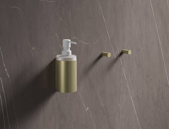 Seifenspender und Handtuchhaken in Messing gebürstet. Die neue Oberfläche wird bei HEWI im umweltschonenden PVD-Verfahren gefertigt. 