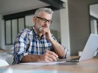 Mann sitzt am Laptop und arbeitet