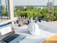 Bauhelm und Laptop auf einer Baustelle