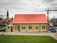 Historisches Gebäude in Eppingen mit einer roten, ins Dach integrierten Photovoltaik-Anlage. Eine homogene Integration von Photovoltaik steigert deren Akzeptanz.