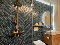 Das wirkt im Bad: Blaue Metrofliesen im Fischgrät­muster einreihig verlegt