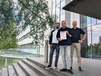Geschützt gegen Cyberattacken: Stellvertretend für alle Kolleg*innen, die dafür sorgen, dass die SMA Systeme höchsten Anforderungen an Datenschutz und IT-Sicherheit gerecht werden, präsentieren (von links) Jonas Dworak, Carsten Dietrich und Dirk Schlote das Zertifikat, das die Norm ETSI EN 303 645 bestätigt.