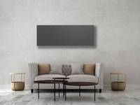 Infrarotheizung an einer Waschbetonwand über einem Sofa.