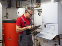 Mann mit Tablet im Heizungskeller